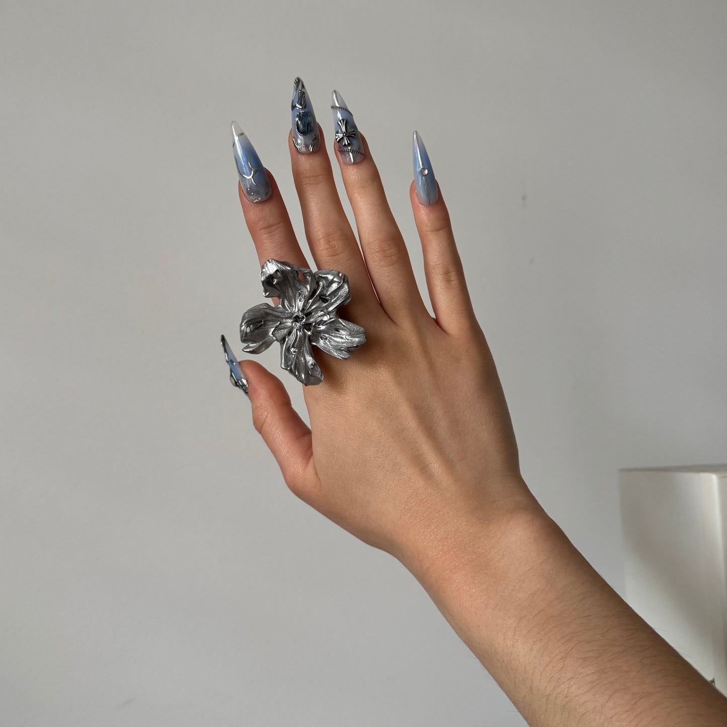 Hand wearing a silver statement flower ring