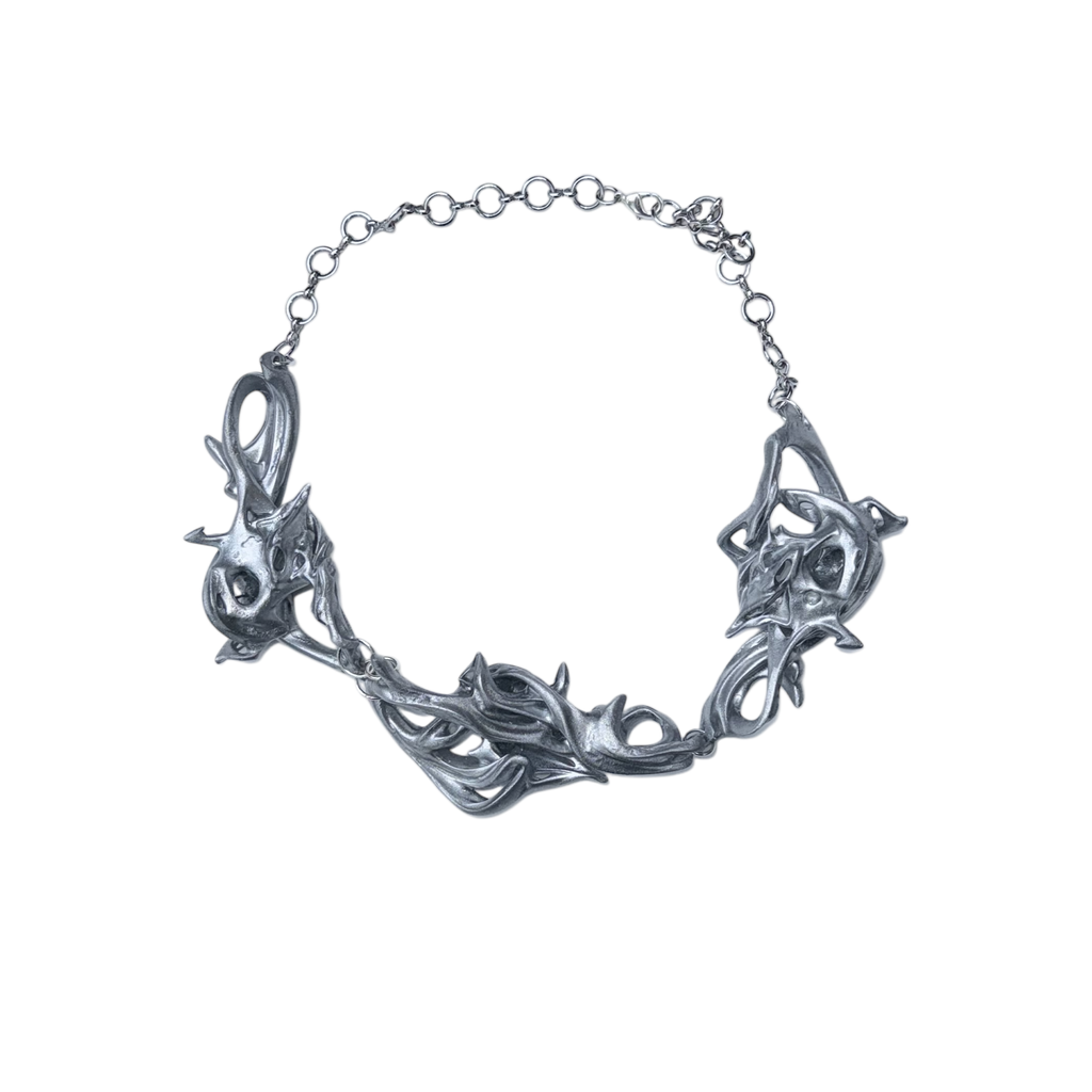 Silver necklace with intricate design on a white background.