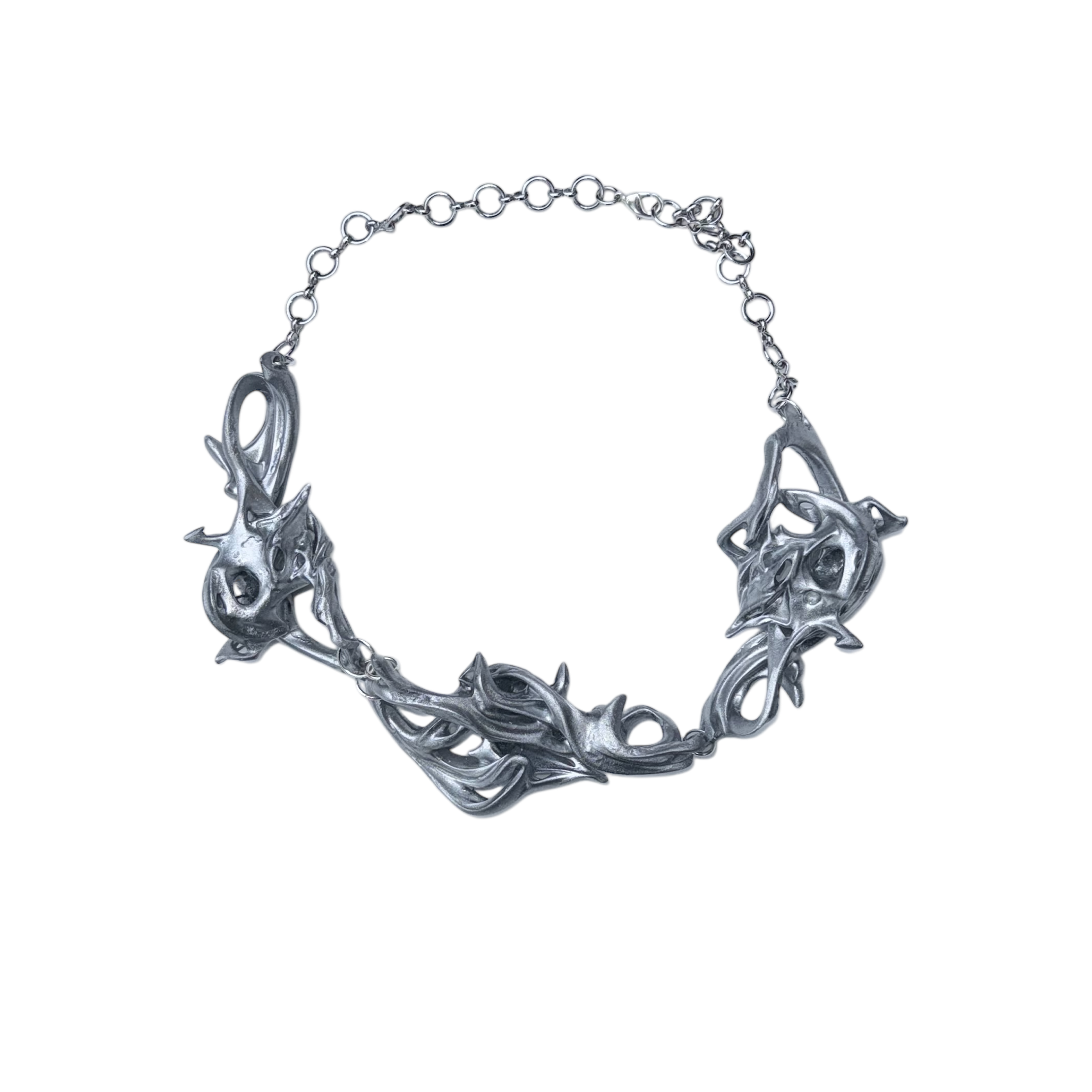 Silver necklace with intricate design on a white background.