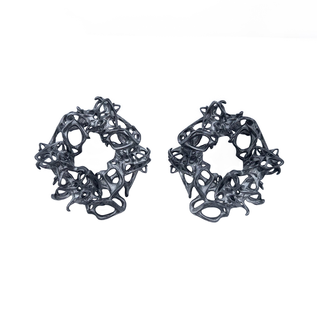 Pair of black lace-like chunky earrings on a white background
