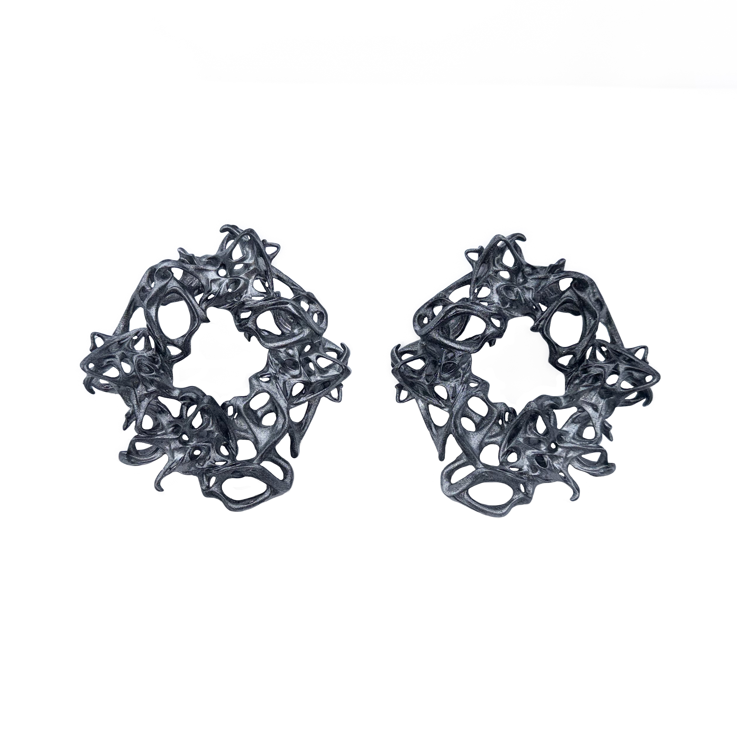 Pair of black lace-like chunky earrings on a white background