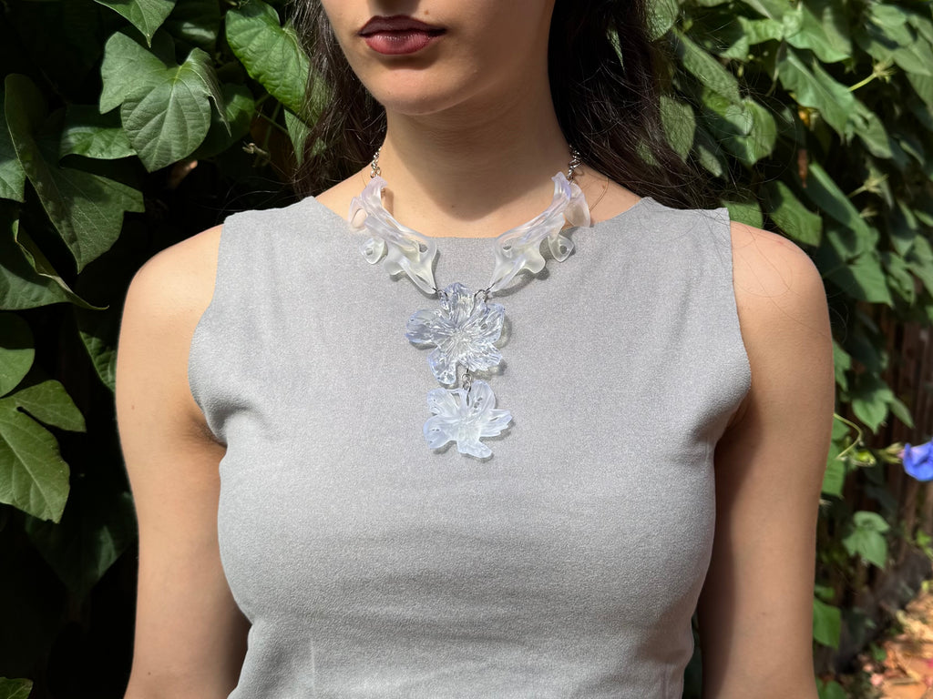 Woman wearing a statement 3D printed floral and fossil inspired resin abstract necklace