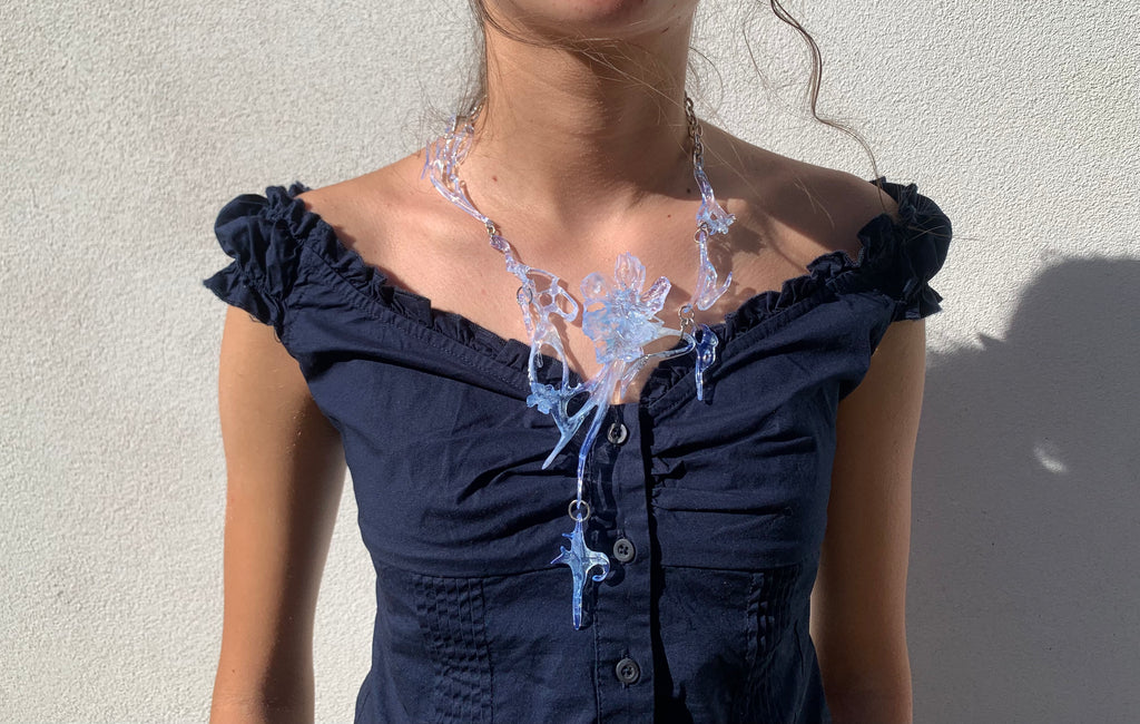 Woman wearing a light blue ethereal statement floral necklace