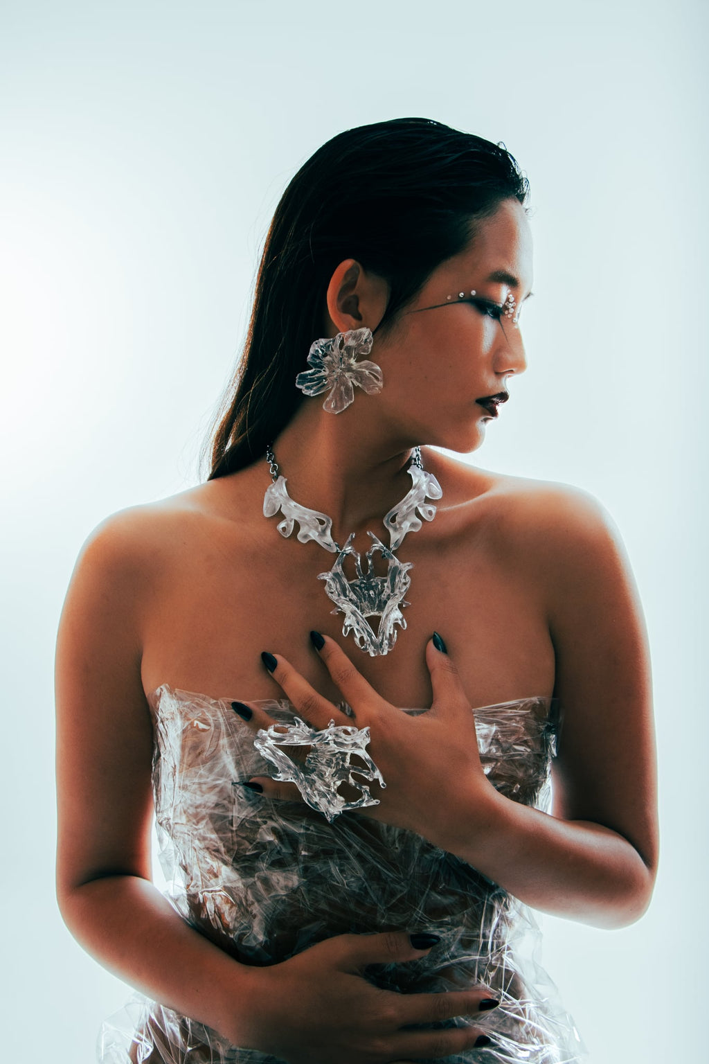 Woman wearing intricate jewelry against a white background