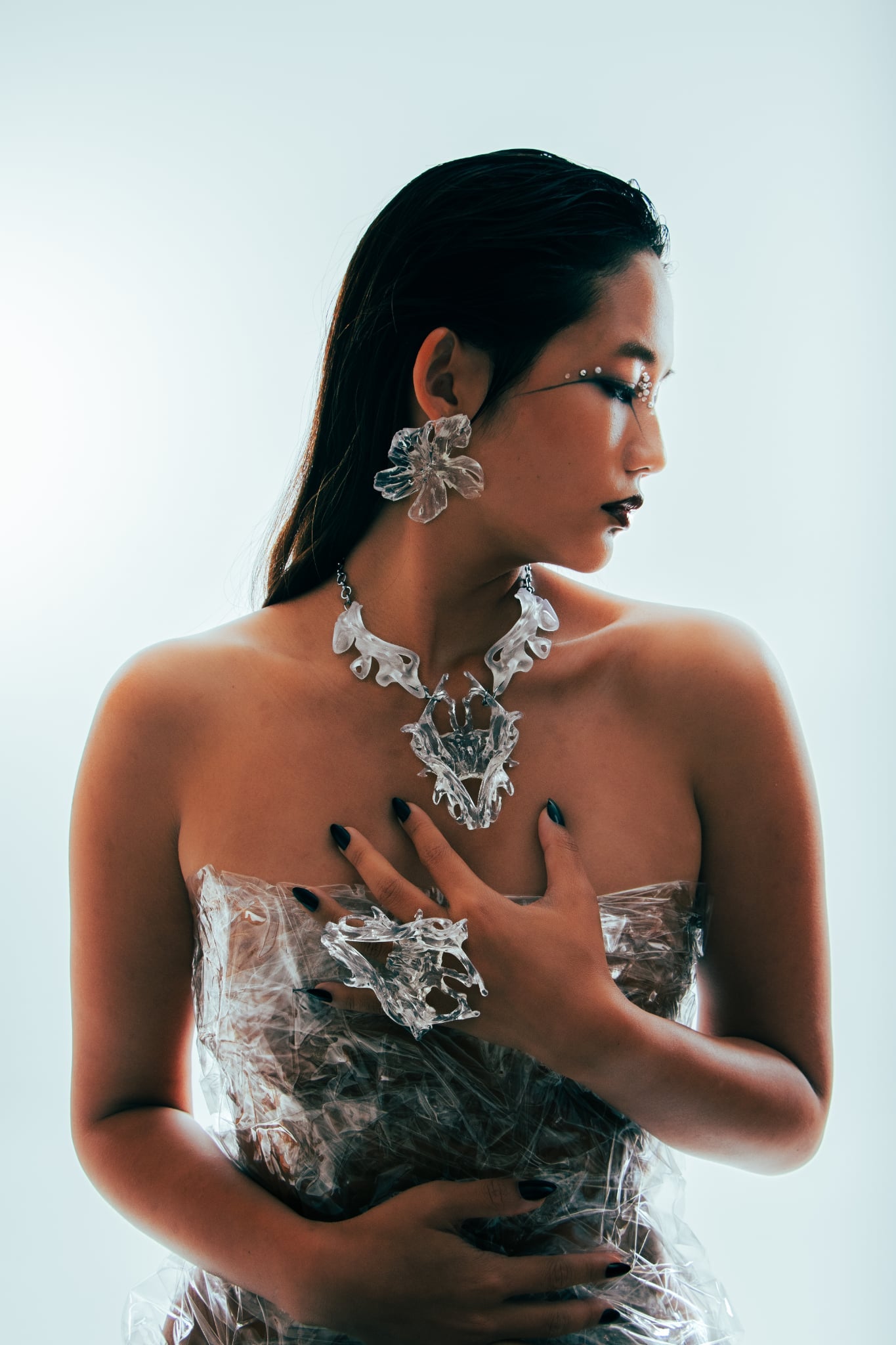 Woman wearing intricate jewelry against a white background
