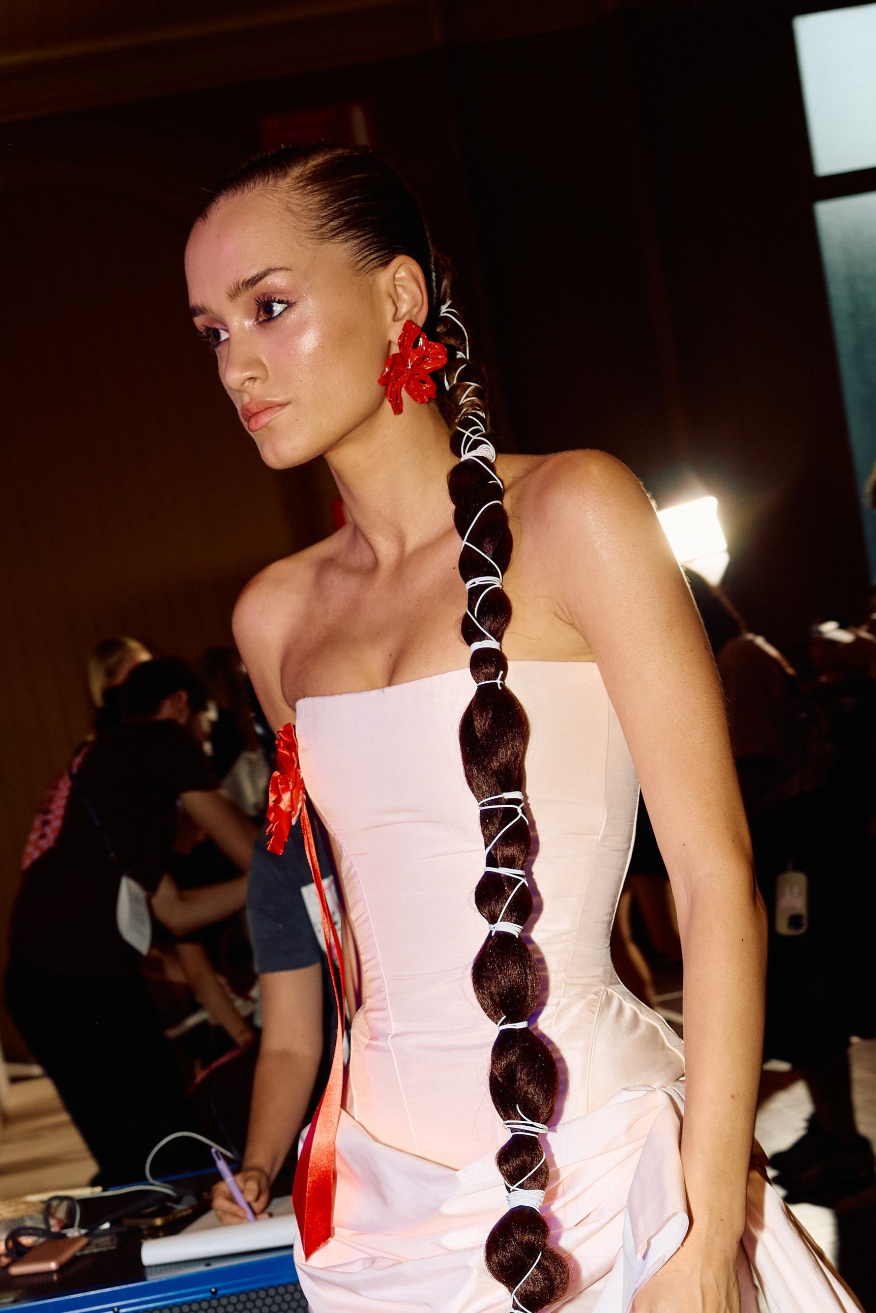 Model wearing red chunky 3D printed statement earrings. 