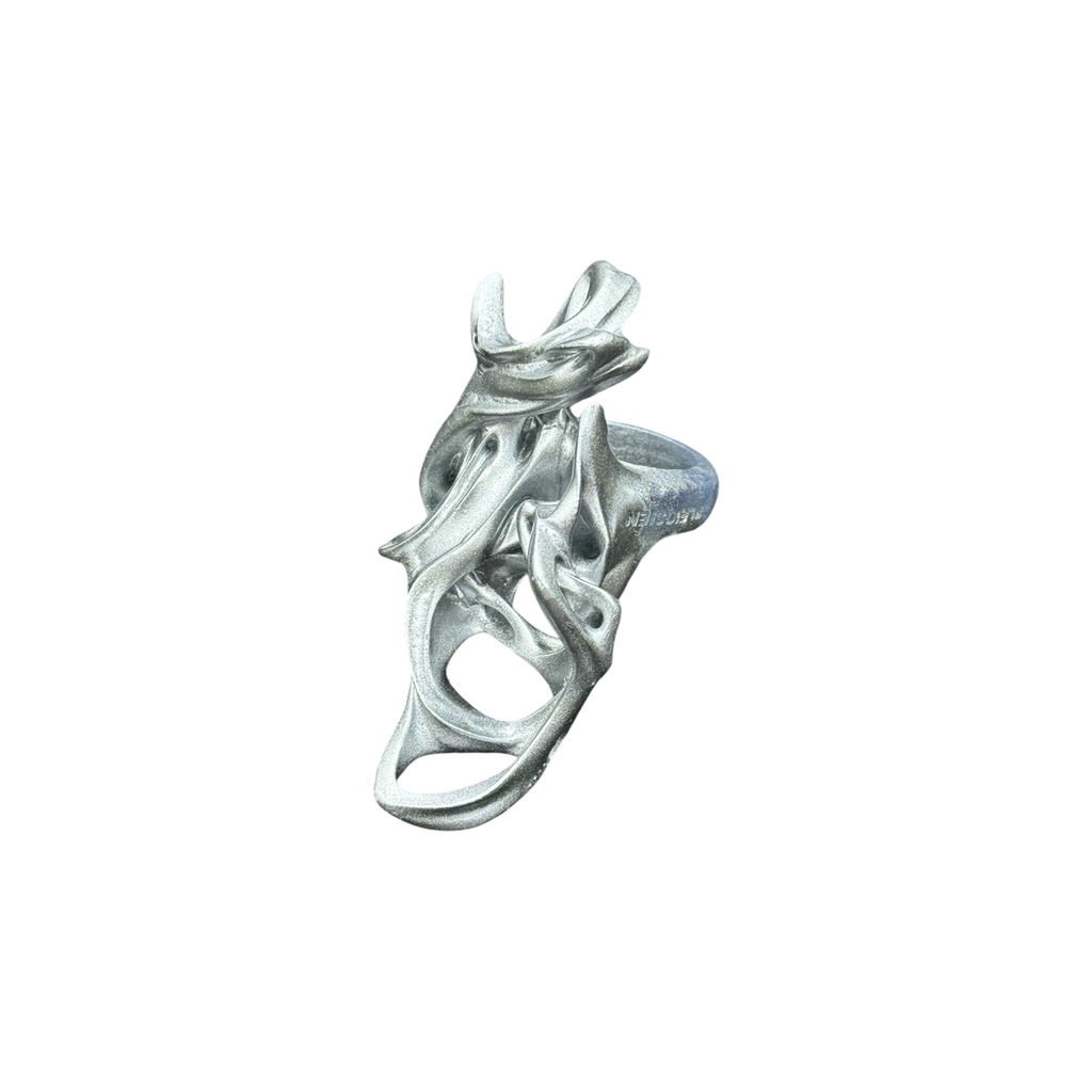 Silver ring with intricate design on a white background
