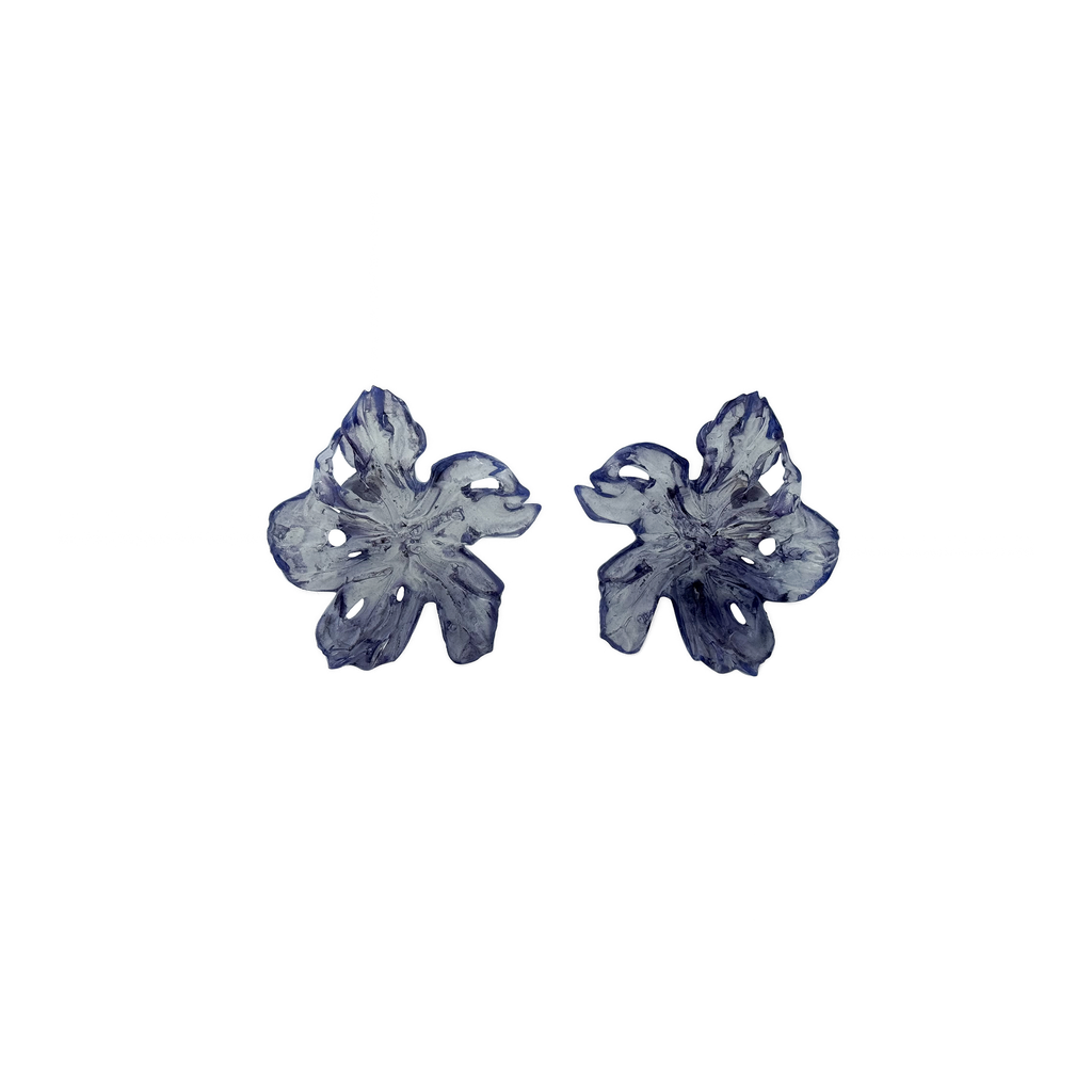 Pair of purple flower-shaped earrings on a white background