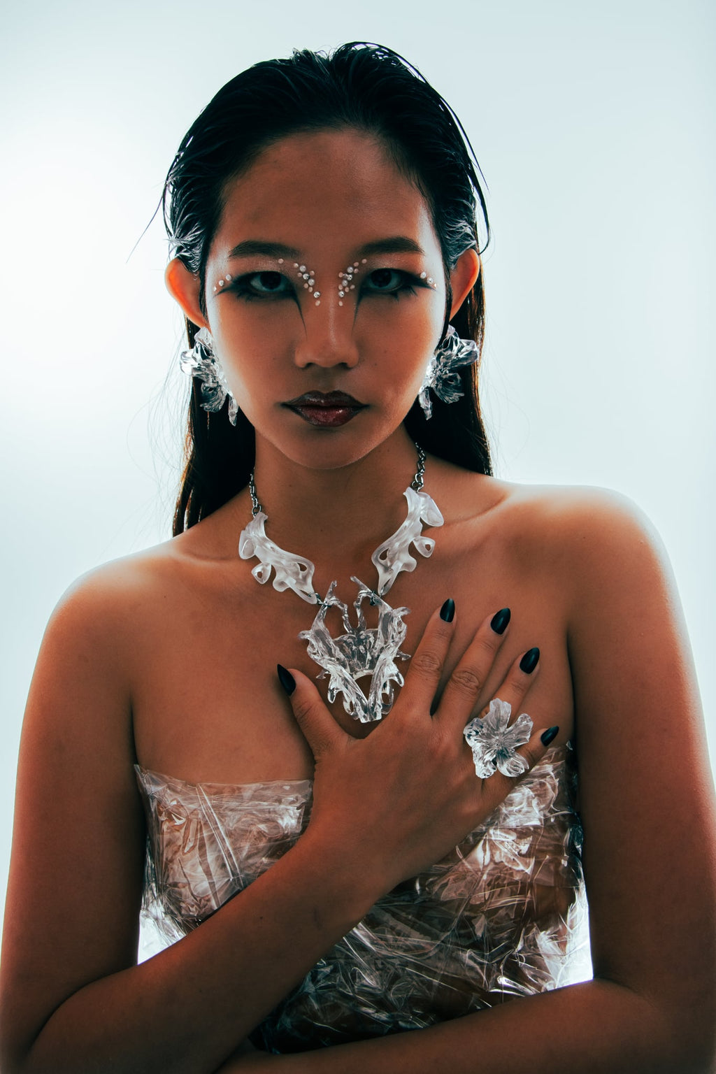 Woman wearing intricate 3D printed statement jewellery on a white background