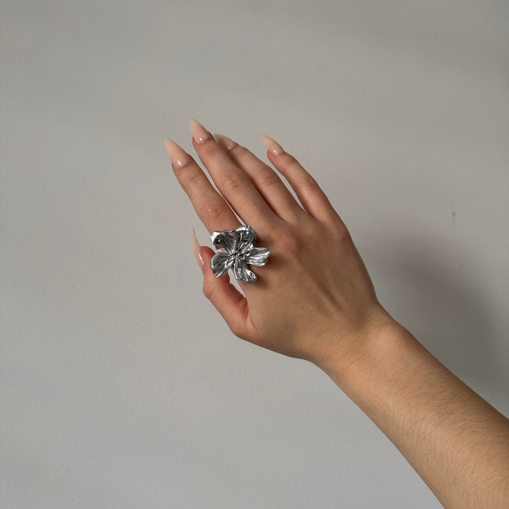 Hand wearing a silver statement flower 3D printed ring